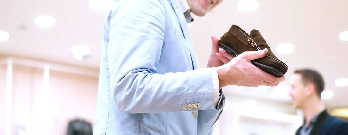 Man Chooses Shoes At Shoe Store